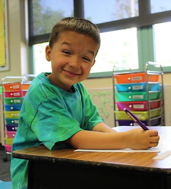 Student laughing while writing