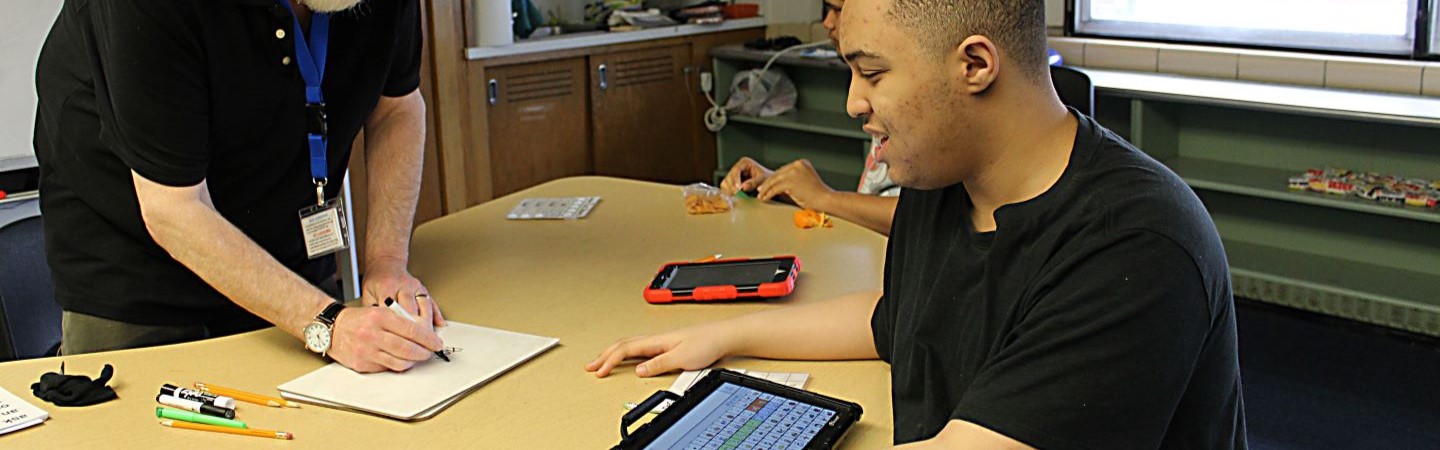 Teacher working with student on assignment 