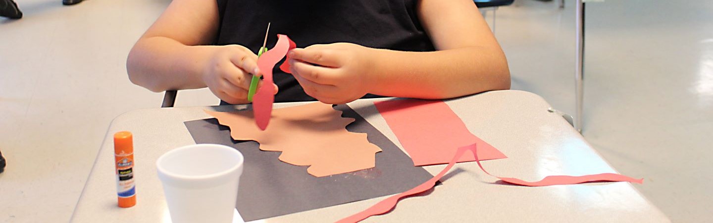 Student working on a craft at his desk