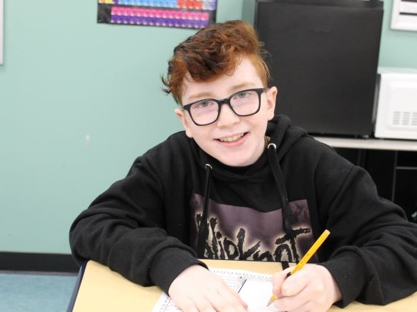 Student smiling while working at his desk