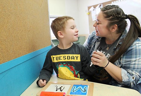 Student and teacher smiling at each other