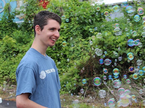 Student smiling while playing with bubbles