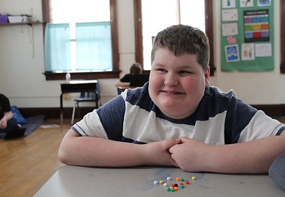 Student smiling in his classroom 