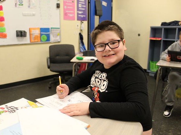 Student smiling working at his desk