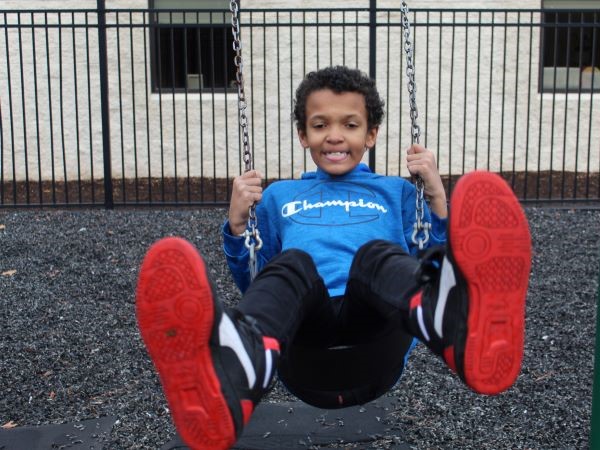 Student swinging on the playground