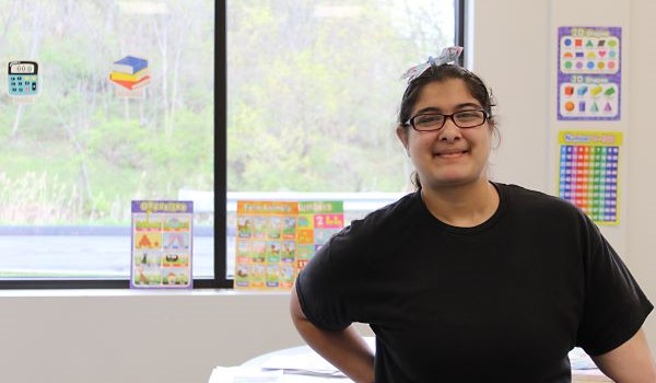 Student smiling with hand on her hip in the classroom