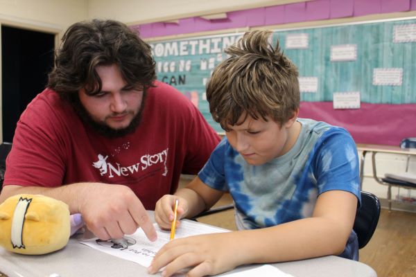 Student and teacher reading through worksheet together