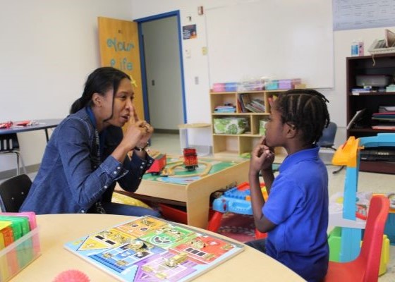 Teacher and student doing speech therapy exercises in classroom