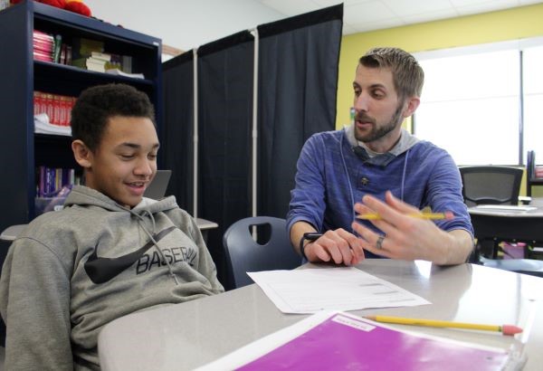 Student and teacher talking at desk