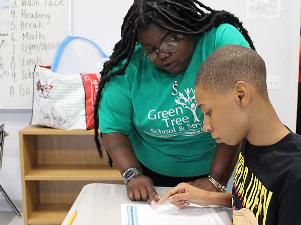 Teacher assisting student with desk work