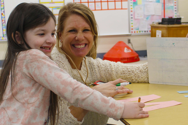 Teacher and student smiling together